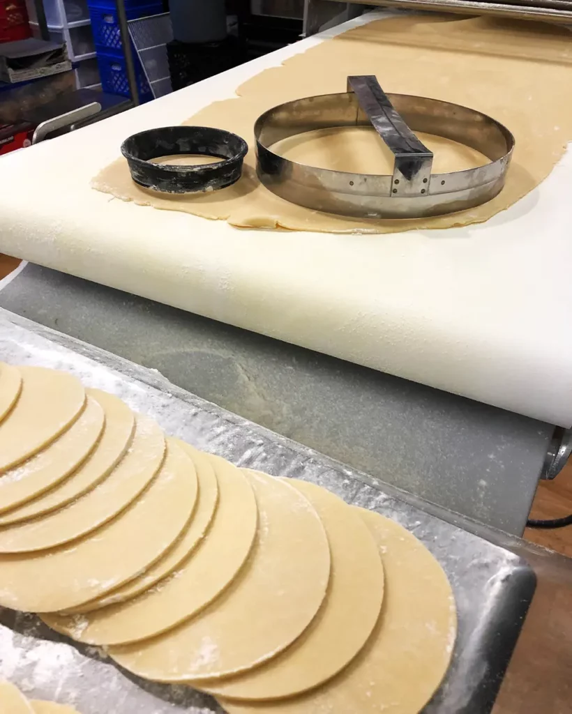Fresh, dual-flour flaky crust pastry dough being hand-cut for our signature homemade butter tarts at Strom's Farm & Bakery in Guelph, Ontario.